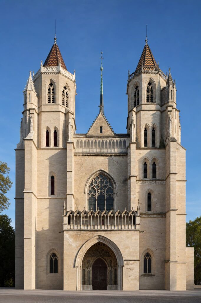 Façade de la cathédrale Saint-Bénigne de Dijon avec sa grande rosace et son architecture gothique, sous un ciel bleu.